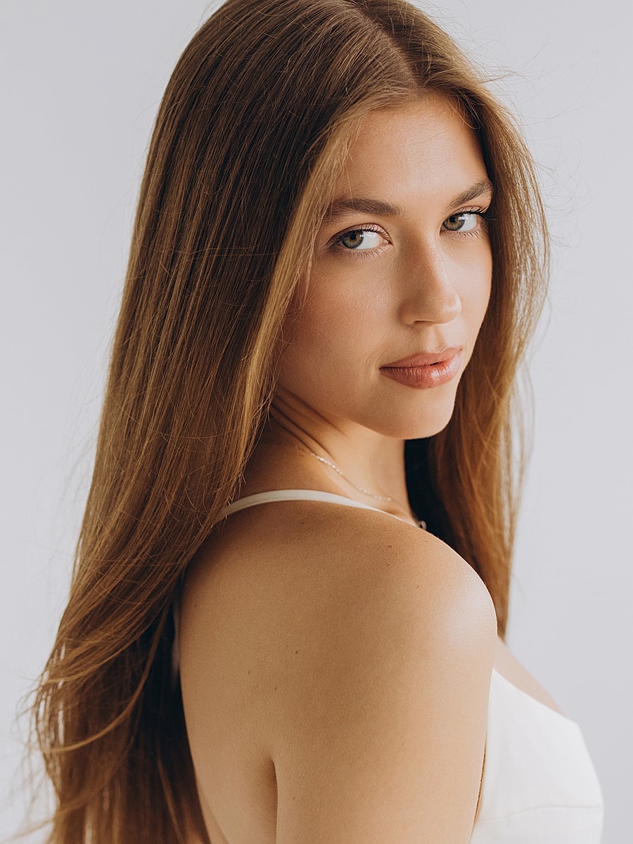 Woman with long hair against light background.